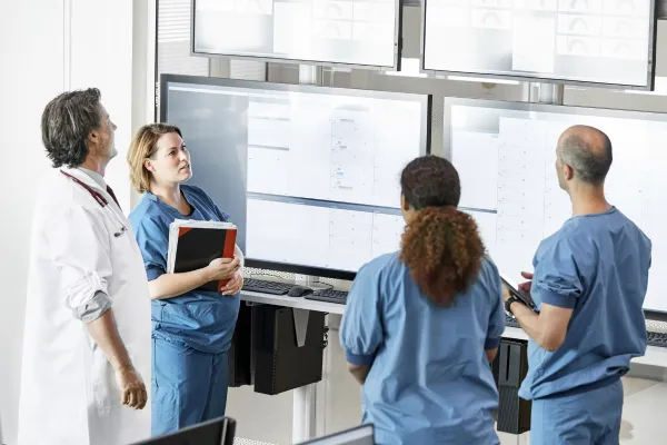 Doctors discussing in front of computer screen